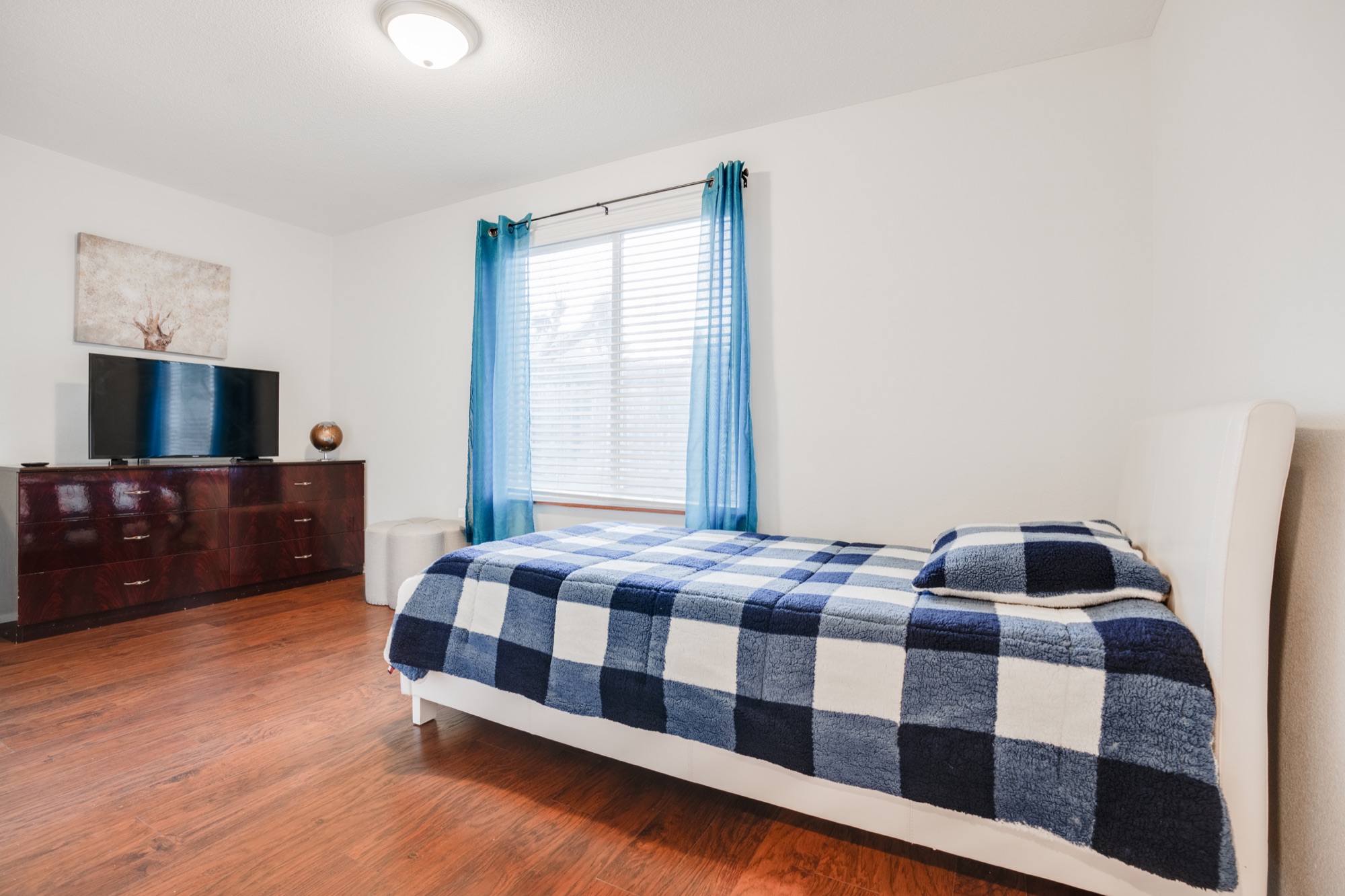 Cozy bedroom with natural light and a dresser