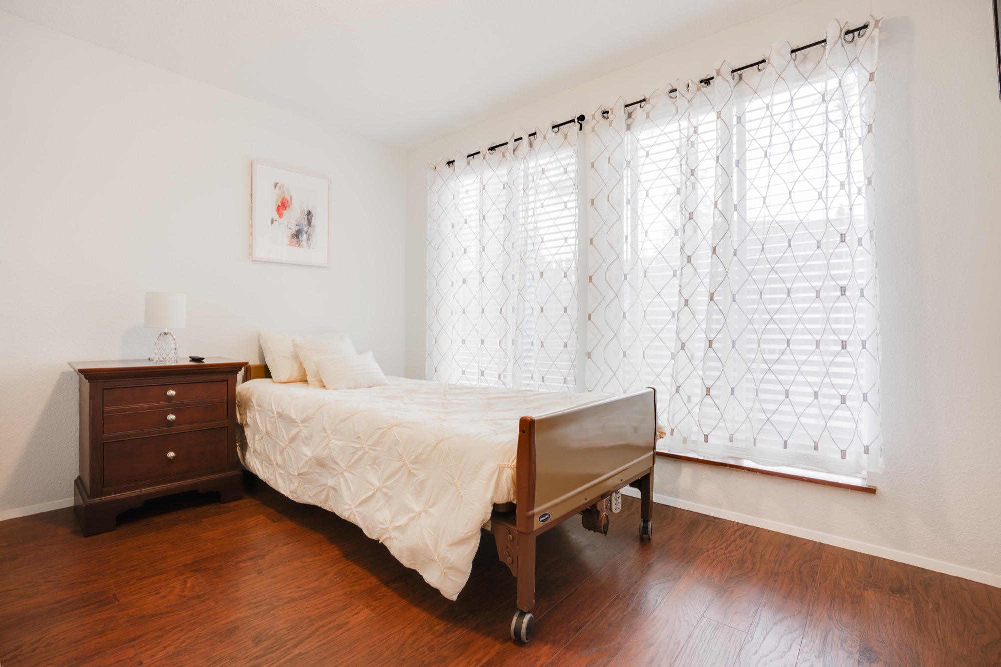 Bright private bedroom with a care bed and nightstand