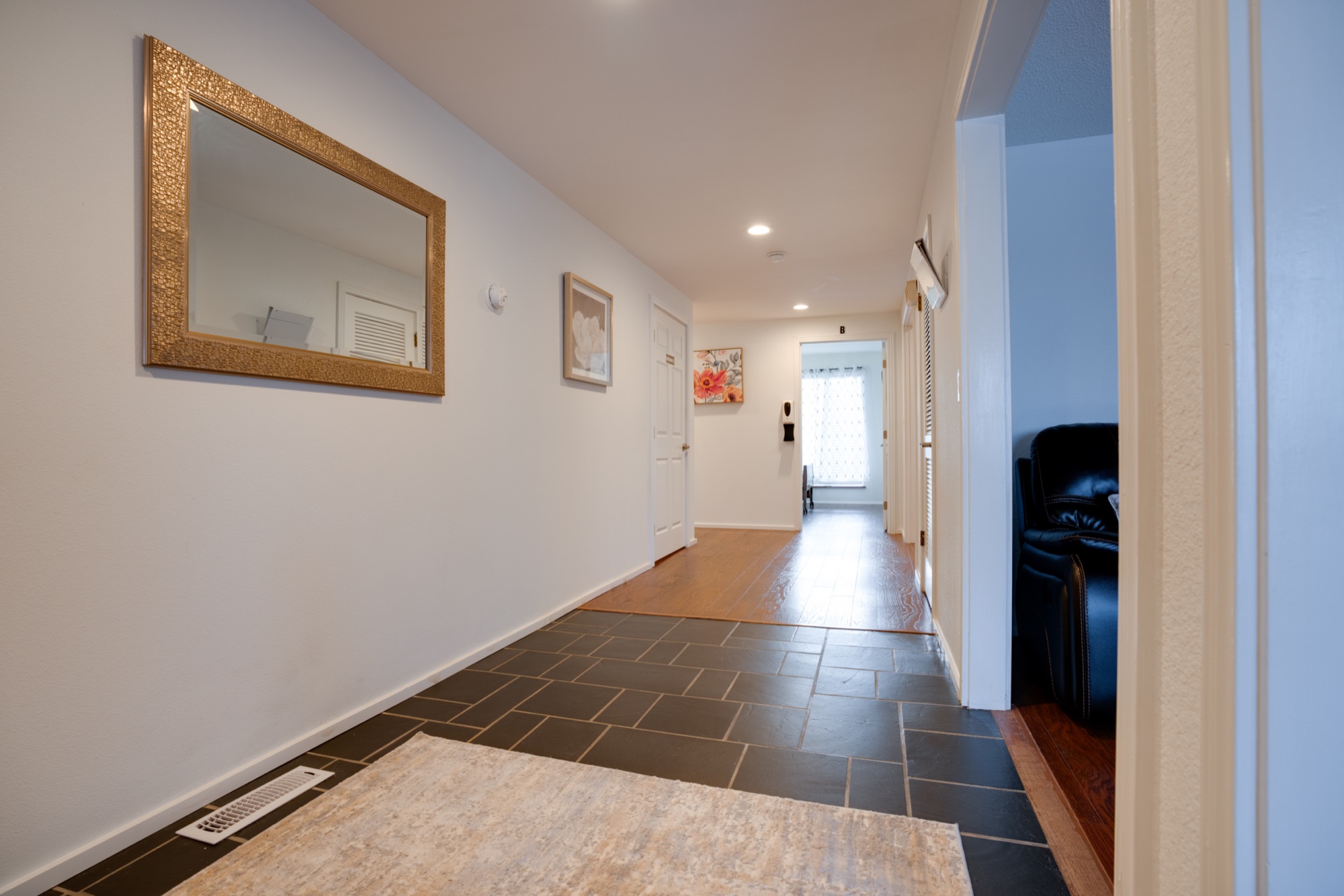 Wide tiled hallway with natural light